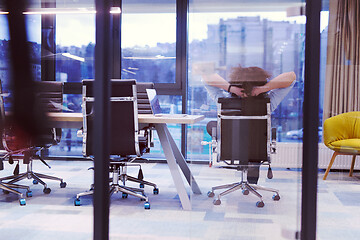 Image showing young businessman relaxing at the desk