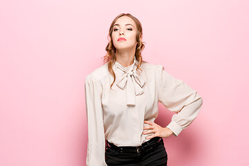 Image showing The serious frustrated young beautiful business woman on pink background