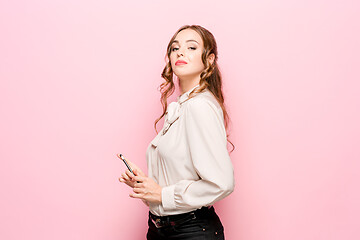 Image showing The serious frustrated young beautiful business woman on pink background