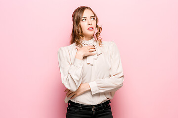 Image showing Let me think. Doubtful pensive woman with thoughtful expression making choice against pink background