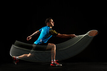 Image showing Young male badminton player over balck background