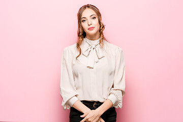 Image showing The serious frustrated young beautiful business woman on pink background