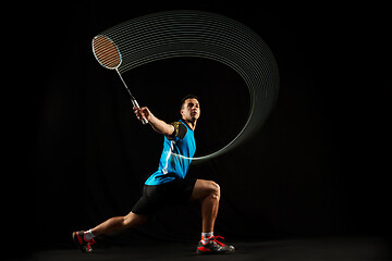 Image showing Young male badminton player over balck background