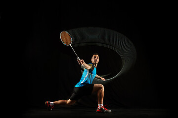 Image showing Young male badminton player over balck background