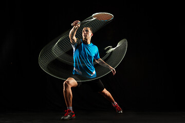 Image showing Young male badminton player over balck background