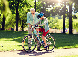 Image showing grandfather and boy with bicycle at summer park