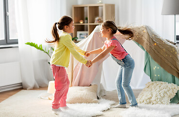 Image showing happy girls playing near kids tent at home