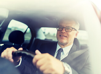 Image showing happy senior businessman driving car