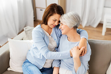 Image showing senior mother with adult daughter hugging at home