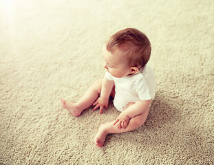 Image showing happy baby boy or girl sitting on floor at home