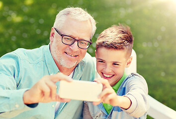 Image showing old man and boy taking selfie by smartphone