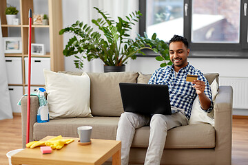 Image showing man with laptop shopping online after cleaning