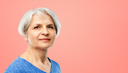 Image showing portrait of senior woman in blue sweater over pink