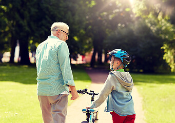 Image showing grandfather and boy with bicycle at summer park