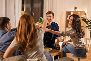 Image showing friends clinking drinks at home in evening