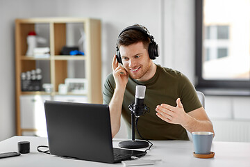 Image showing man with laptop and microphone at home office