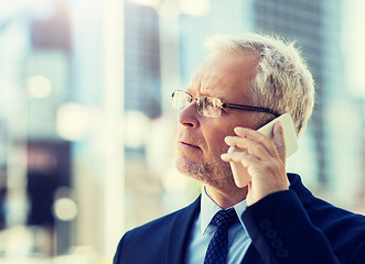 Image showing senior businessman calling on smartphone in city