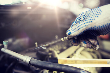 Image showing mechanic with dipstick checking motor oil level