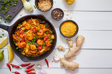 Image showing Fresh fried noodles with vegetables with shrimps served in black iron pan. With various ingredients