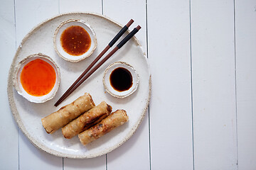 Image showing Fried Chinese Thai or Vietnamese traditional spring rolls or nems served on ceramic plate