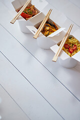 Image showing Three take away paper boxes filled with asian food placed in row on white