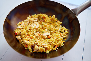 Image showing Delicious Thai dish in hot Wok. Fried chicken with rice and vegetables.