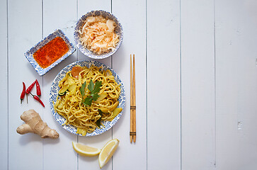 Image showing Tasty and Fresh Noodles with Chicken and vegetables served on ceramic plate with chopsticks