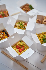 Image showing Asian take away or delivery food concept. Paper boxes placed on white wooden table