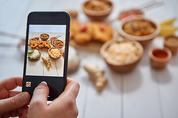 Image showing Woman taking a photo with smartphone of deep fried Crispy chicken in breadcrumbs