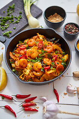 Image showing Fresh fried noodles with vegetables with shrimps served in black iron pan. With various ingredients