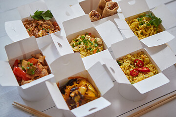 Image showing Asian take away or delivery food concept. Paper boxes placed on white wooden table