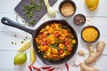 Image showing Fresh fried noodles with vegetables with shrimps served in black iron pan. With various ingredients