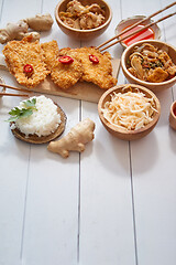 Image showing Deep fried Crispy chicken in breadcrumbs served on white wooden table with salad, spices