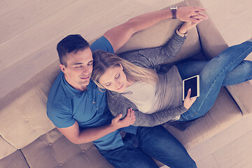 Image showing youg couple in living room with tablet top view