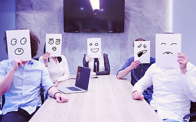 Image showing startup business team holding a white paper over face