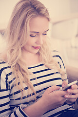 Image showing woman sitting on sofa with mobile phone