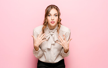 Image showing Beautiful female half-length portrait isolated on pink studio backgroud. The young emotional surprised woman