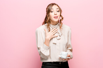 Image showing The serious frustrated young beautiful business woman on pink background