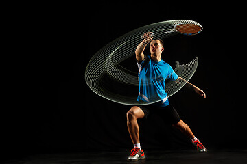 Image showing Young male badminton player over balck background