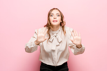 Image showing Beautiful female half-length portrait isolated on pink studio backgroud. The young emotional surprised woman