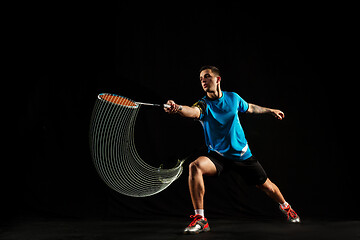 Image showing Young male badminton player over balck background