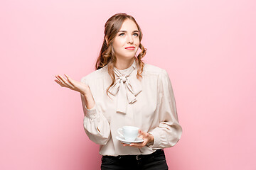 Image showing The serious frustrated young beautiful business woman on pink background