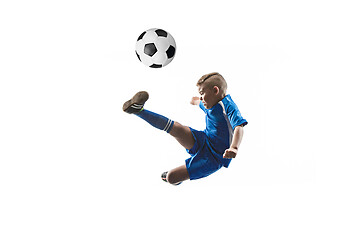 Image showing Young boy with soccer ball doing flying kick