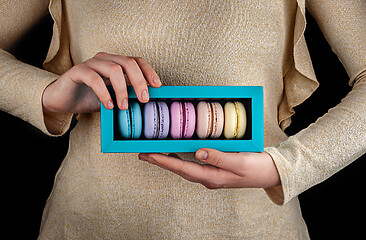 Image showing Female hands hold macaroons in gift box