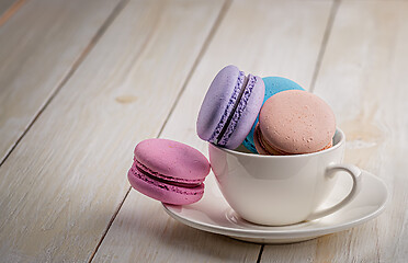 Image showing Macaroons in cup on wooden table