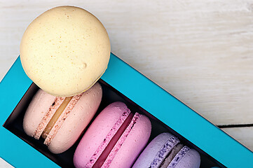 Image showing Macaroons in box and one on top 