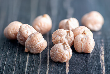 Image showing Several dry chickpeas on wooden desk