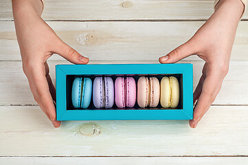 Image showing Girl\'s hands holding box of macaroons