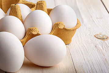Image showing Eggs near the tray on white table closeup