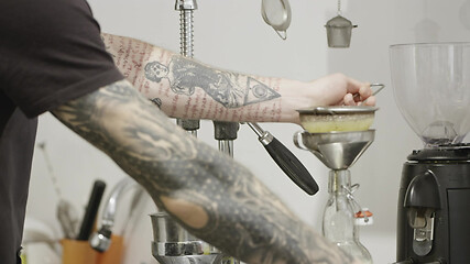 Image showing Barista with a tattoo prepares lemon, natural juice in a bottle for making a summer drink. Slow motion, Full HD video, 240fps, 1080p.